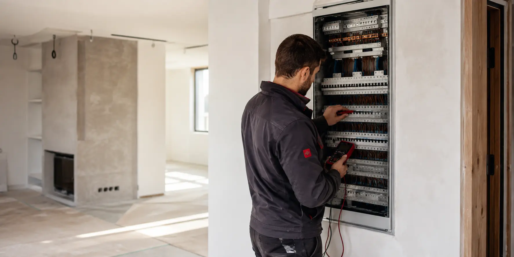 Elektriker bei der Prüfung einer modernen Elektroverteilung